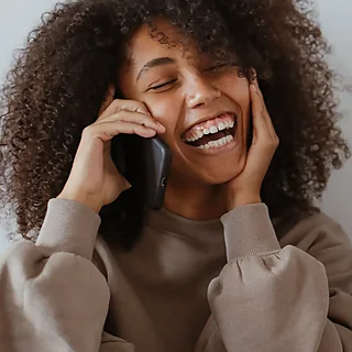 Une personne au téléphone, en train de rire